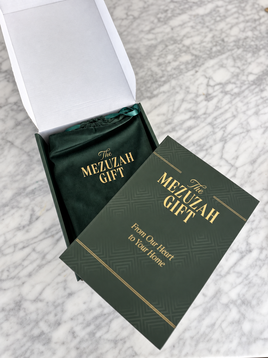 The Mezuzah Gift presentation packaging with green velvet pouch and gold lettering